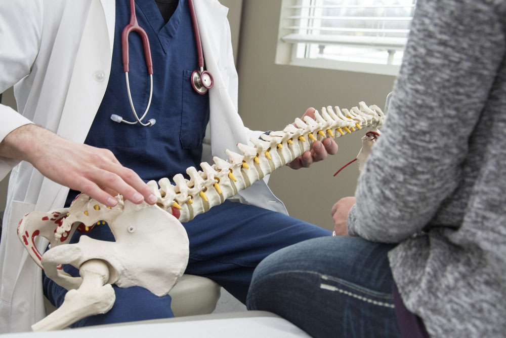 Chiropractor talking to his client about chiropractic care.